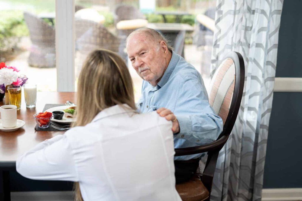 Adult woman seated with senior man